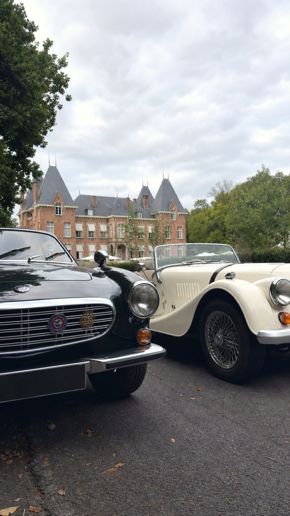 Twee oldtimers voor een kasteel