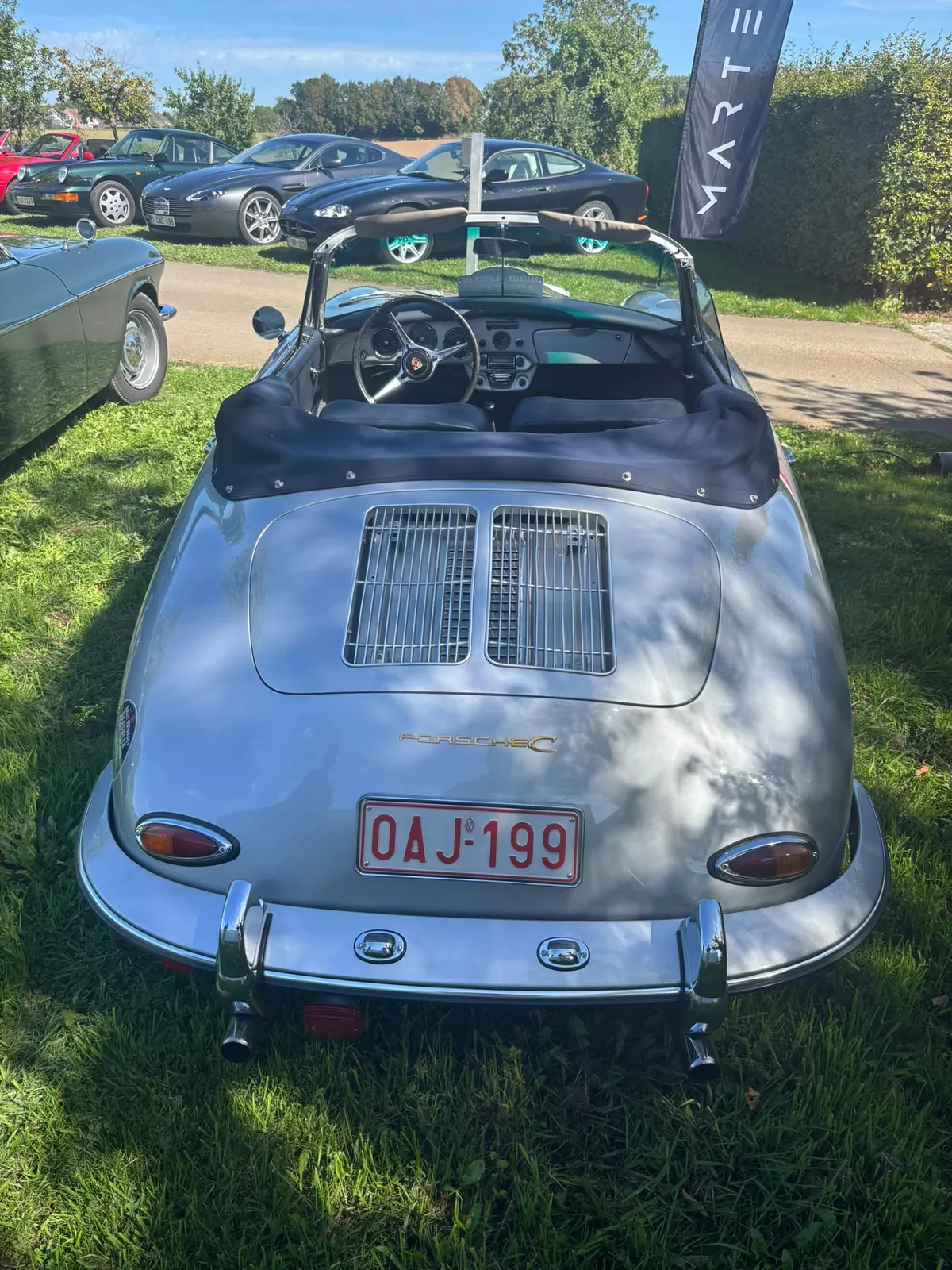 Zilverkleurige Porsche cabrio tussen de deelnemende wagens