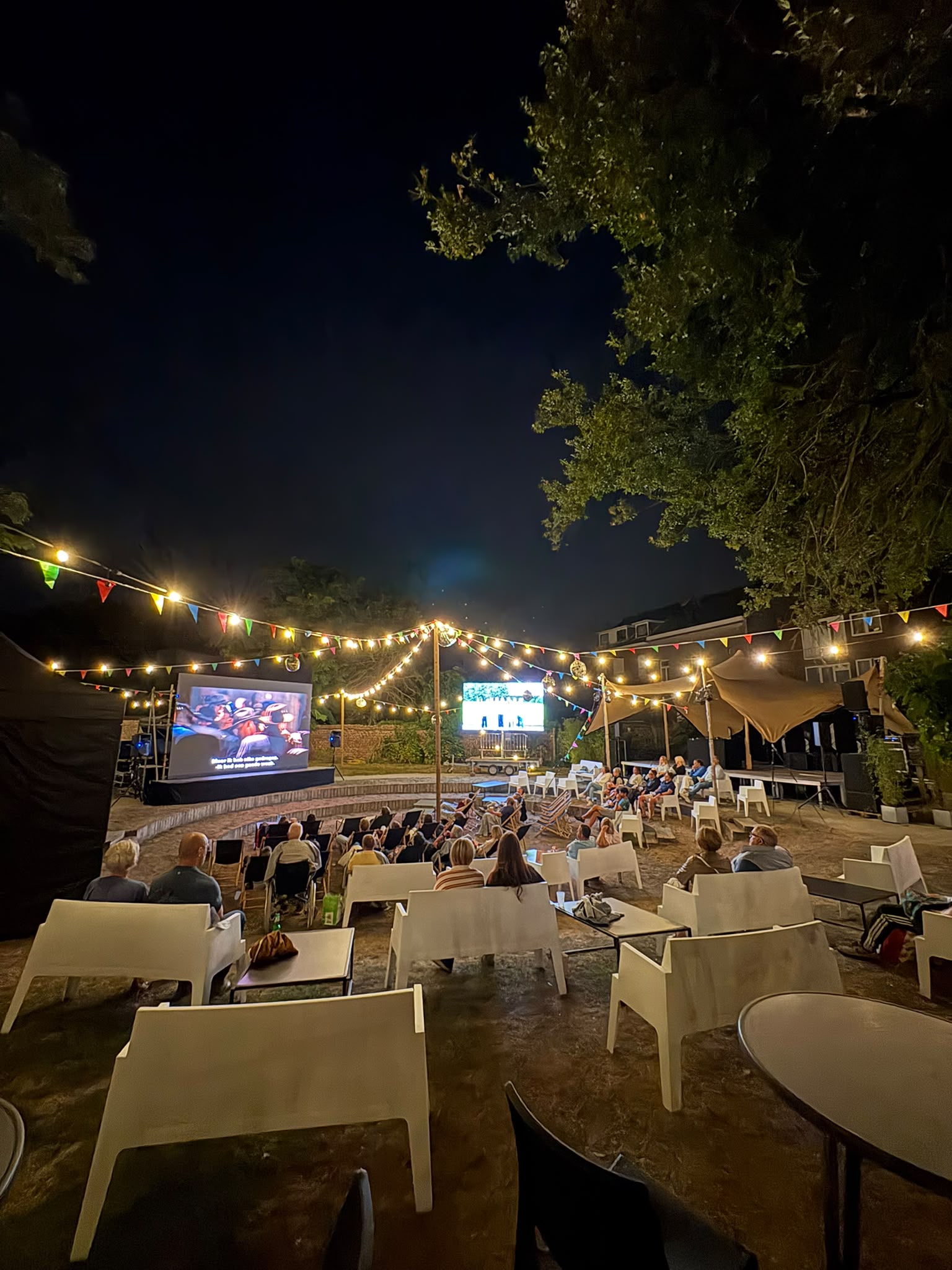 Publiek tijdens de openluchtcinema in de Dekenijtuin in Lennik