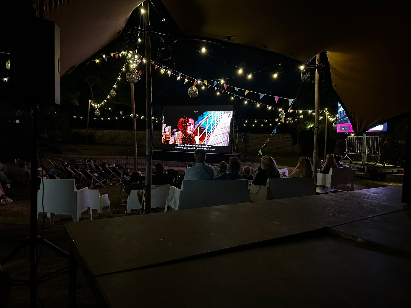 Filmscherm en publiek vanuit de tent